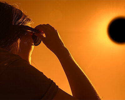 Man looking at eclipse through sunglasses