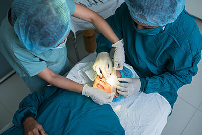 Overhead image of patient on operating table having a patch put over eye after surgery
