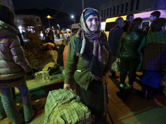 An ethnic Armenian woman from Nagorno-Karabakh carries her suitcase to a tent camp after arriving to Armenia's Goris in Syunik region, Armenia, Sept. 29, 2023. (AP Photo/Vasily Krestyaninov)