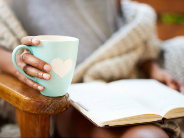 person reading a book with a cup of coffee