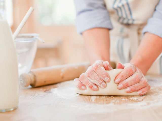 woman kneading bread dough on a countertop