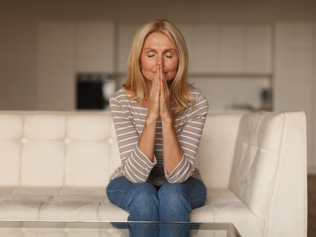 woman on couch praying