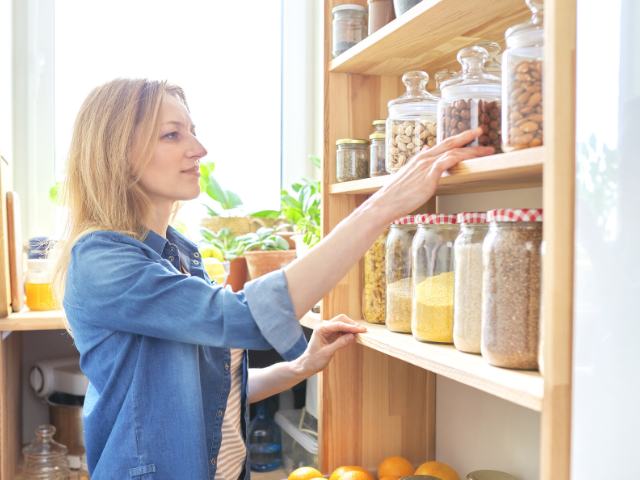 woman looking through her kitchen pantry