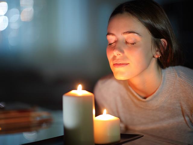 woman smelling scented candle