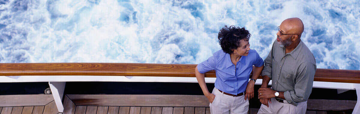 two people on a cruise ship deck with water behind them