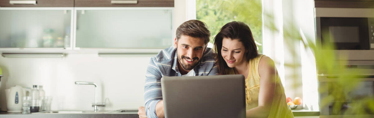 Man and woman on a computer viewing a travel insurance comparison