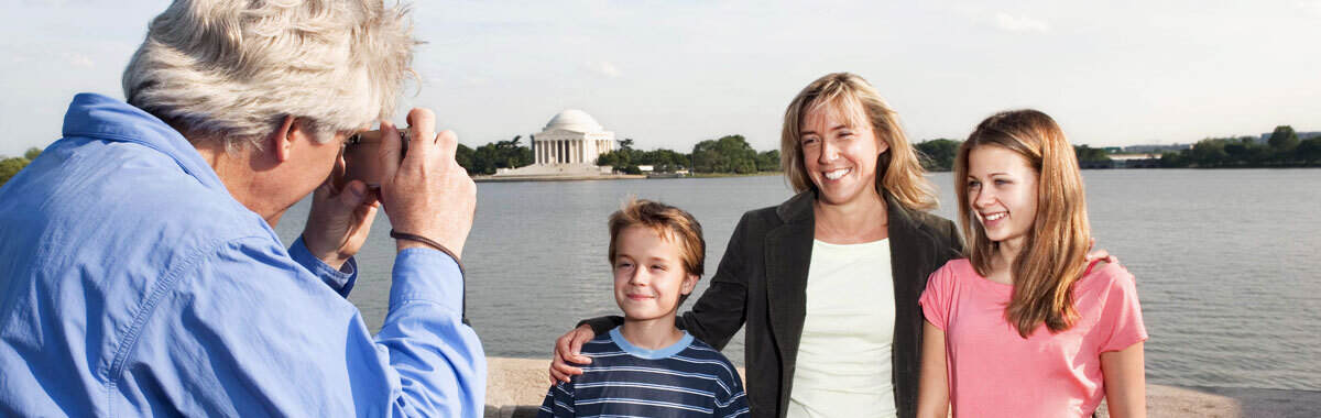 Family with kids travel to Washington DC with Jefferson Memorial in background