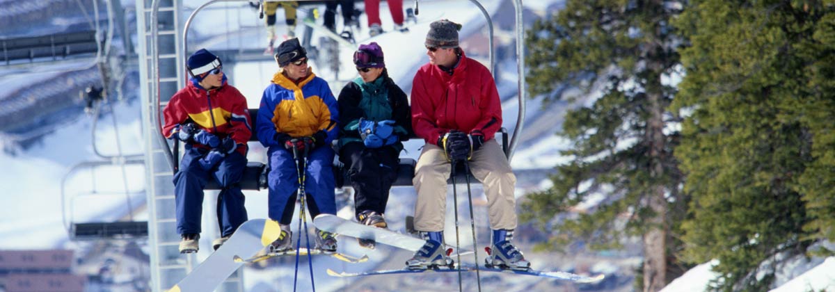 Skiers and snowboarders on a ski lift in Aspen, Colorado