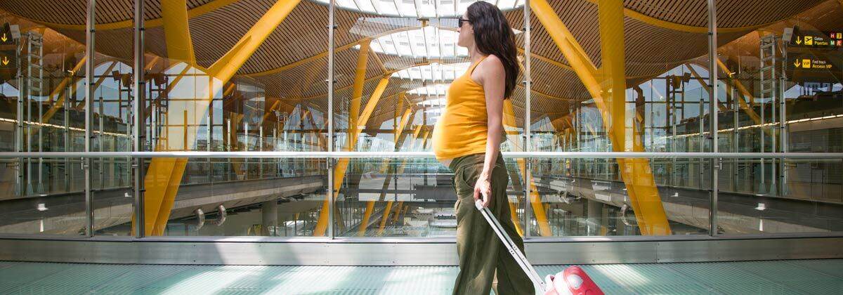 Woman in airport traveling while pregnant