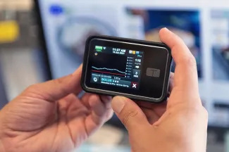 A person holds a glucose monitor.
