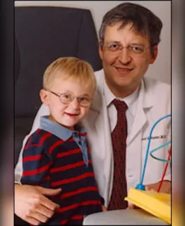 boy in glasses poses with doctor