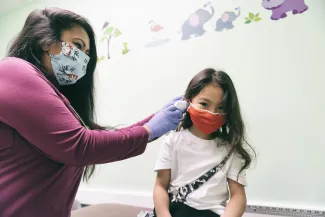 Clinician examines girl's ear
