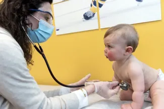 Female clinician checks baby's heart rate