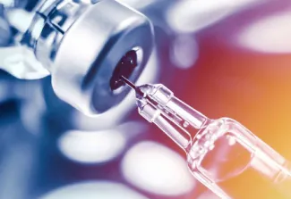 Syringe draws medicine out of a vial