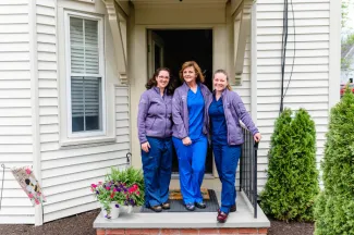 three medical women in front of a doorway