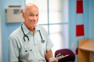 a smiling medical doctor with a clipboard