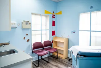 a pediatric exam room with lighthouse-themed wall decals