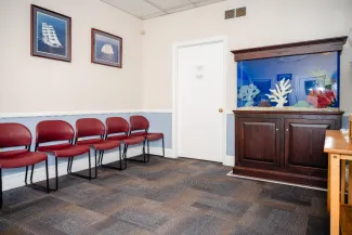 a pediatric office waiting room with chairs and a fish tank