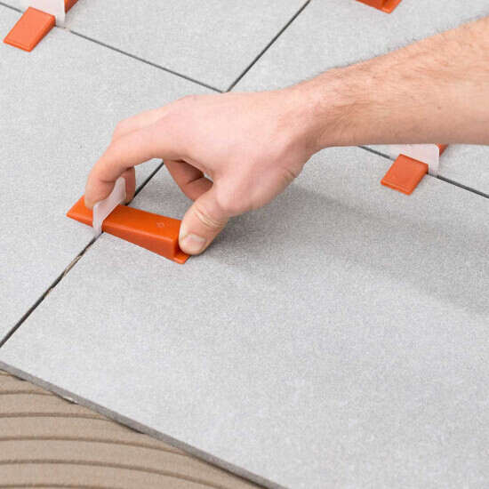 Raimondi leveling clip spacer underneath the tiles along the 4 sides