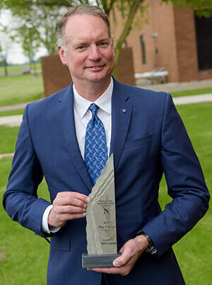 Bryan Keller, CEO of Keller Logistics Group, with the Making a Difference Award for Operation KAVIC outside of Northwest State Community College building.