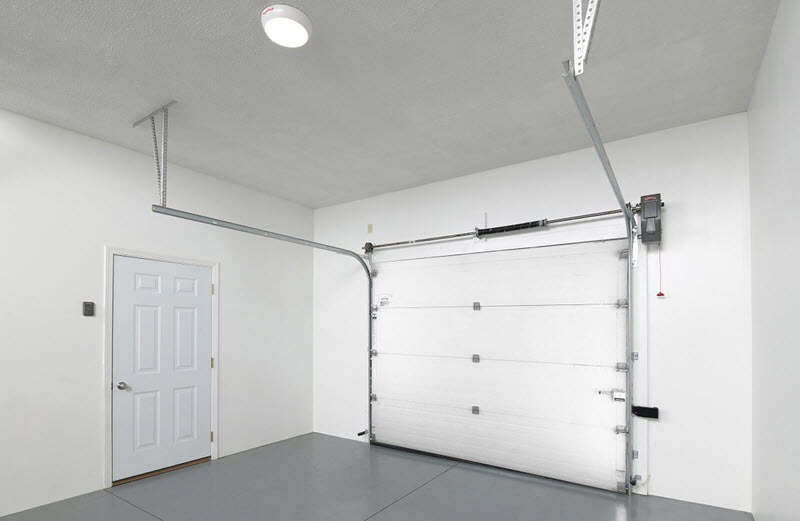 clean garage with white garage door and white entry door