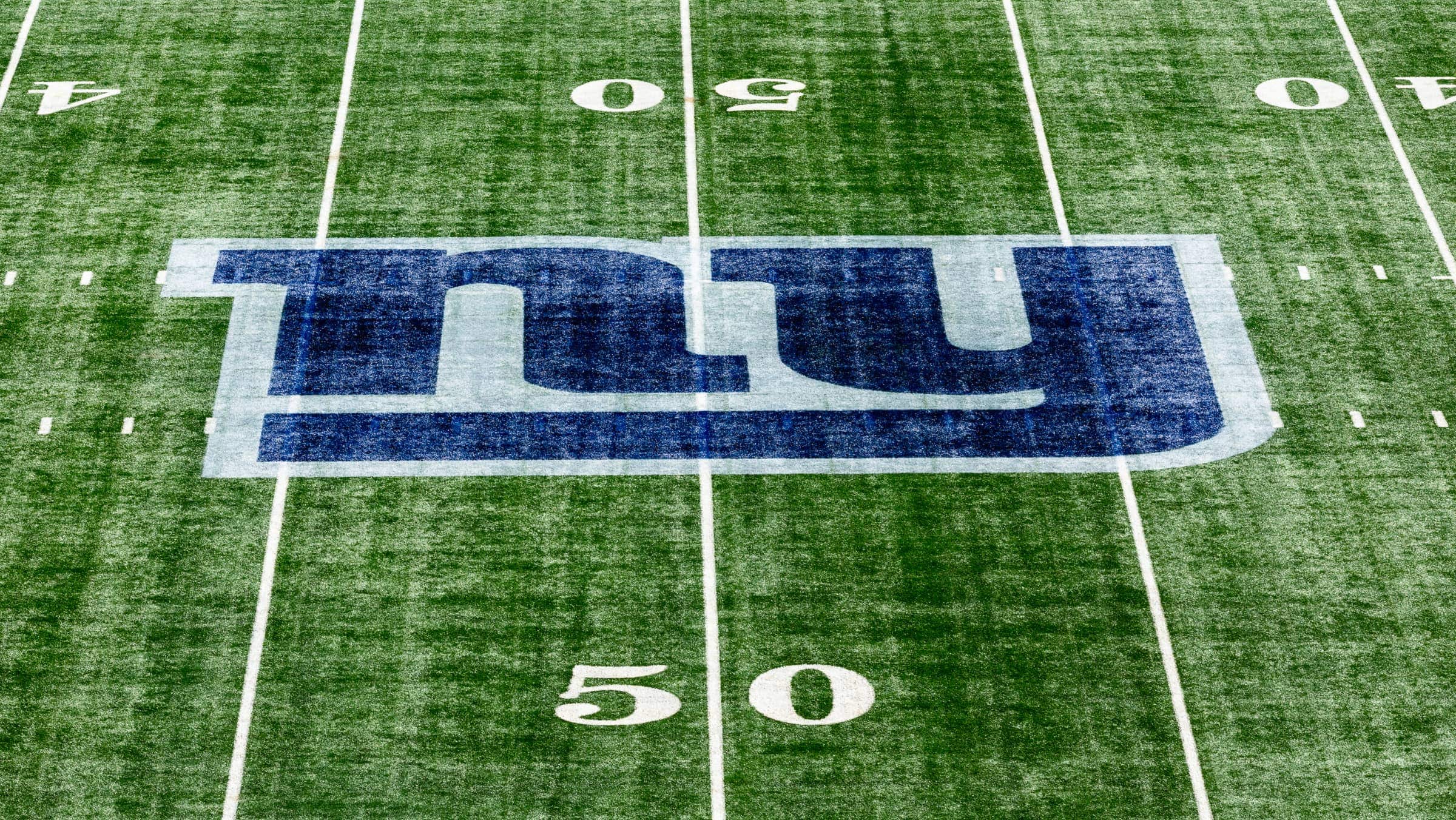 NY Giants logo on football field.