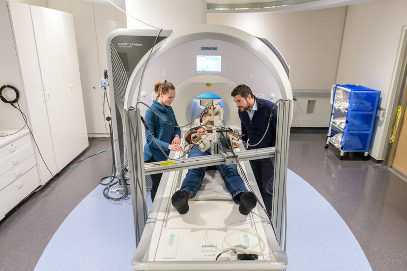 Fabrizio Sergi (right) has created a niche area by developing MRI-compatible robots to study how human brains and muscles work during natural and effortless movements. Many robots used in medical research can’t be used with an MRI machine, making it difficult to study brain activity during their use.