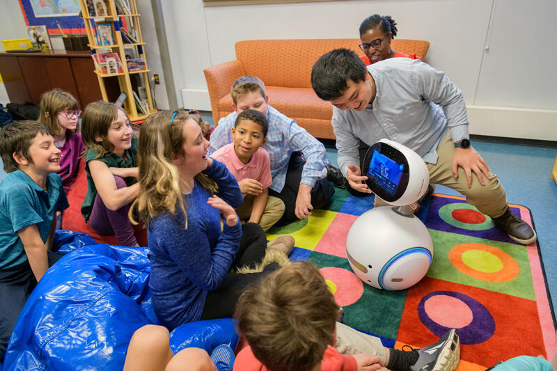 Fifth graders at The College School, located on UD’s Newark Campus, watch Zenbo the social robot, while doctoral student Yan-Ming Chiou guides the conversation and Prof. Tia Barnes looks on.