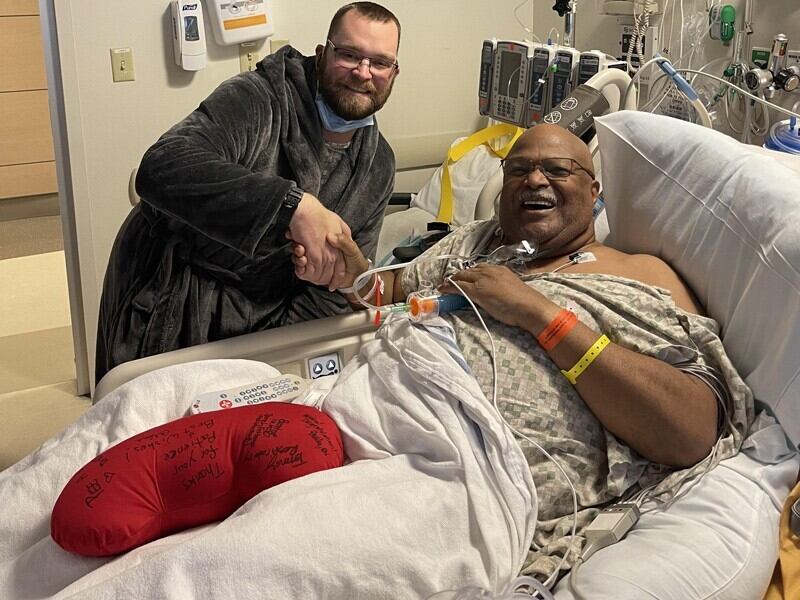 Photo from a hospital room. Bill Sumiel (right) and Tim Letts smile following Sumiel’s kidney transplant surgery at Christiana Hospital in December of 2021. Letts donated a kidney to Sumiel after the two met in Letts’ car while he was driving for Uber. 