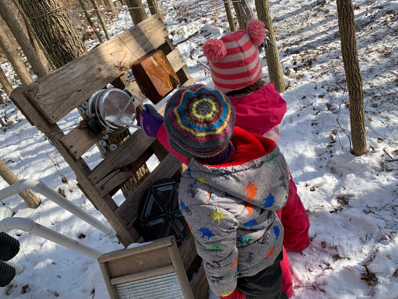 Preschool children bundle up as they engage in nature-based, outdoor learning activities at UD’s Lab School. 