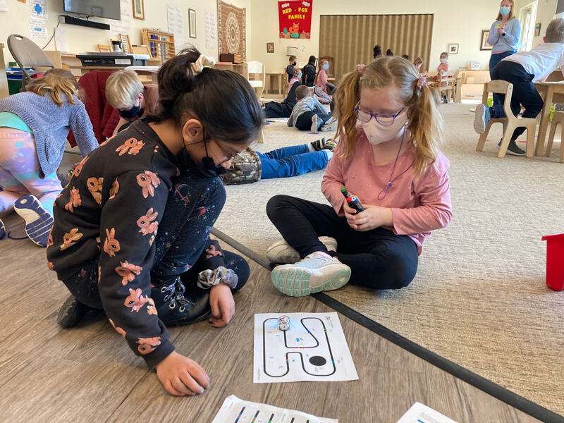 4-H Educator Jill Jackson watches on as students in grades 2 and 3 work with Ozobot robots.