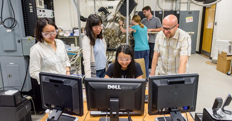 In this 2017 photo (before pandemic masking restrictions), University of Delaware Professor Joshua Zide (right) works with students in the molecular beam epitaxy lab in DuPont Hall. For his commitment to excellence in graduate training, Zide has won the 2022 Outstanding Doctoral Advising and Mentoring Award.