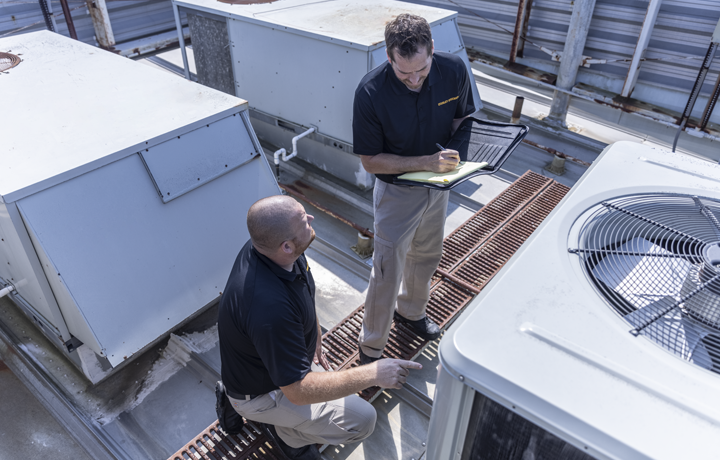 Air duct technicians inspecting HVAC system of building
