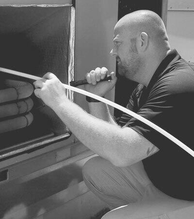 Stanley Steemer technician inspecting an HVAC rooftop unit