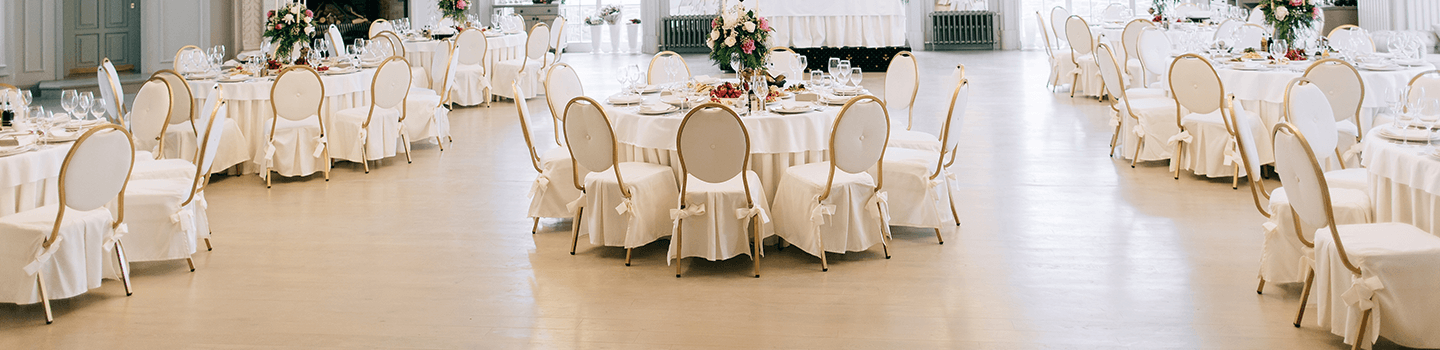 Event space with round tables with white covers and chairs