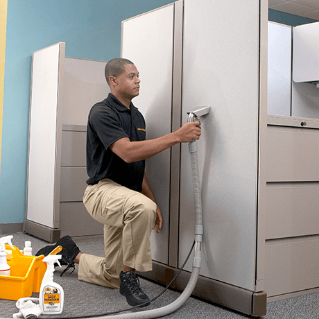 Stanley Steemer technician cleaning cubicle fabric