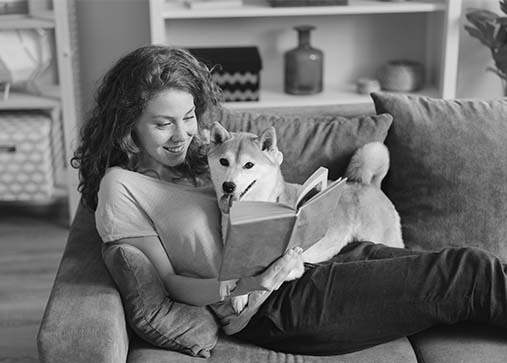 Woman and dog lounging on clean couch