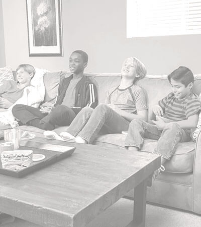 Young kids sitting on a couch in a living room.