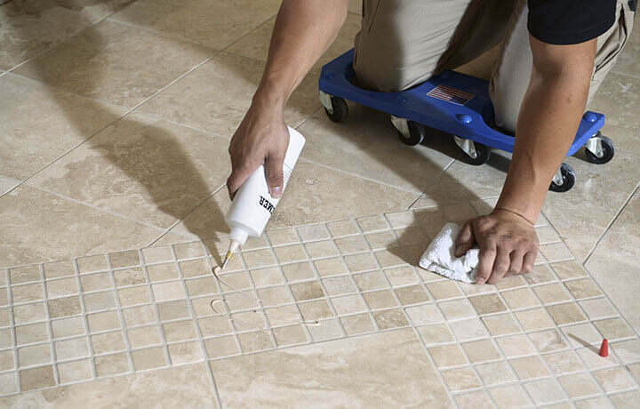Stanley Steemer technician applying sealant to natural stone floors.