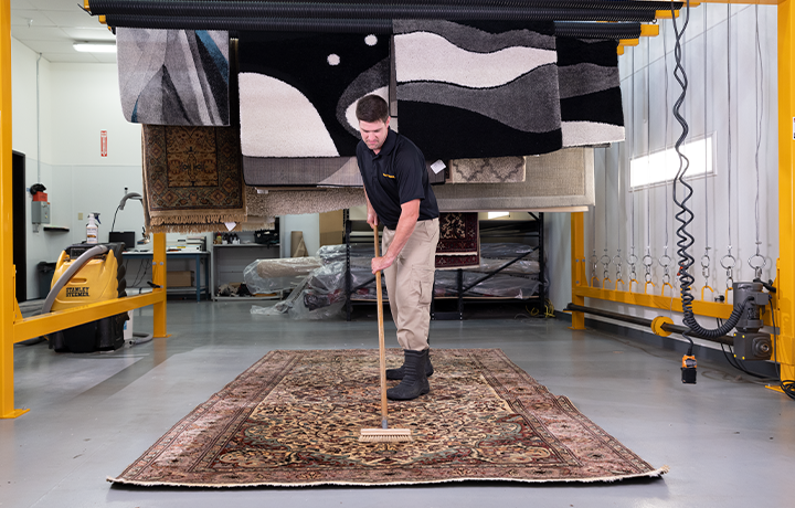 Stanley Steemer technician spring cleaning area and oriental rugs in off-site rug cleaning facility