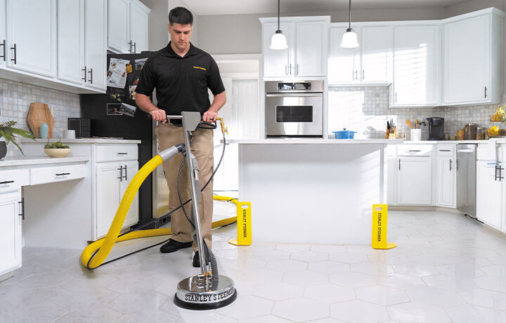 Stanley Steemer technician spring cleaning tile and grout floor in kitchen