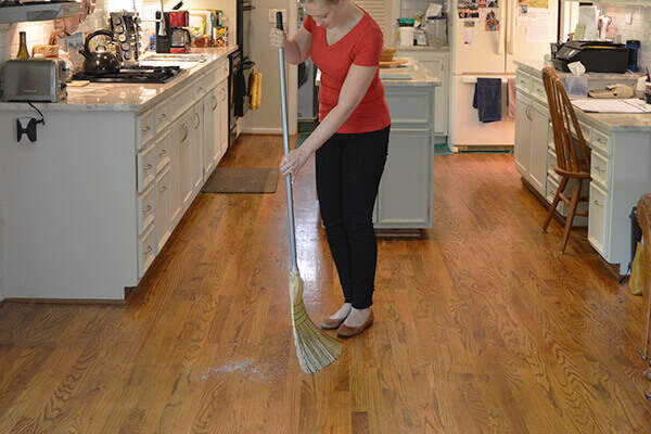 Woman sweeping and cleaning hardwood