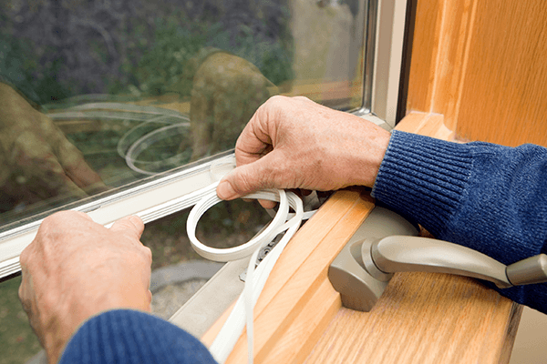 Person weatherstripping  windows in home