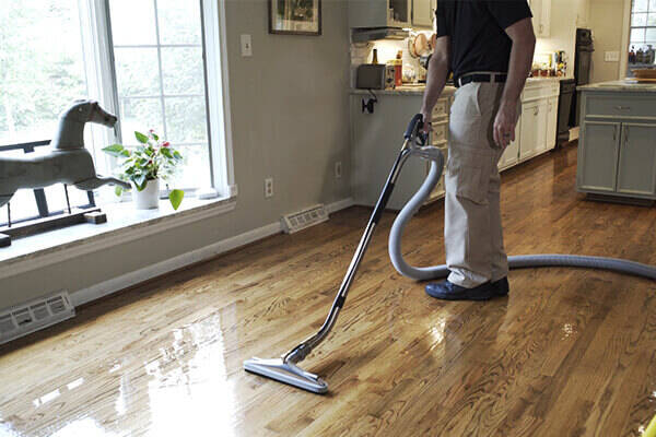Stanley Steemer technician professionally cleaning hardwood floor
