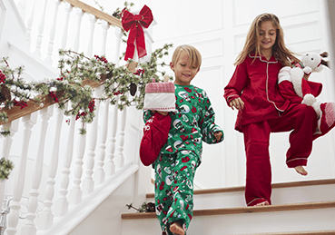Boy and girl walking down stairs in pajamas during holiday season