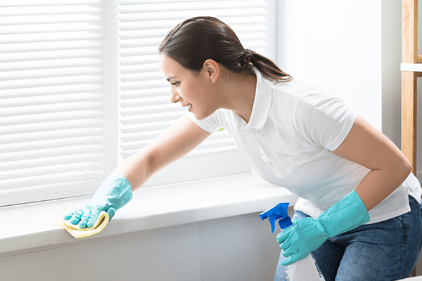 Woman with cleaning gloves on wiping down wall