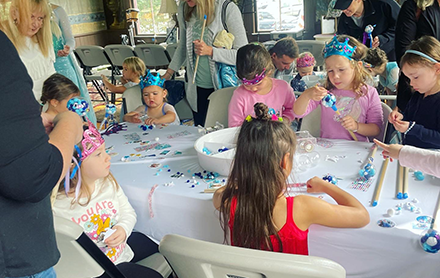 A group of children doing crafts together at a birthday party hosted by The Makers Club.