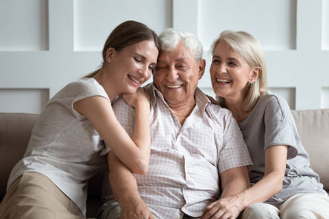 Cheerful three-generation family sitting on couch