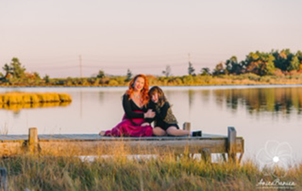 A mother and daughter posing by a lake while they are photographed by Anica Banica Photography.