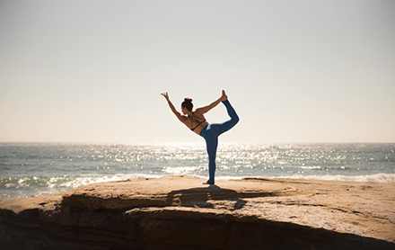 A yogi posing by the beach.